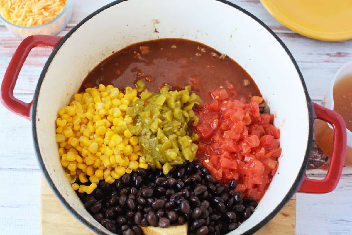 dutch oven filled with corn, green chiles, diced tomatoes and black beans