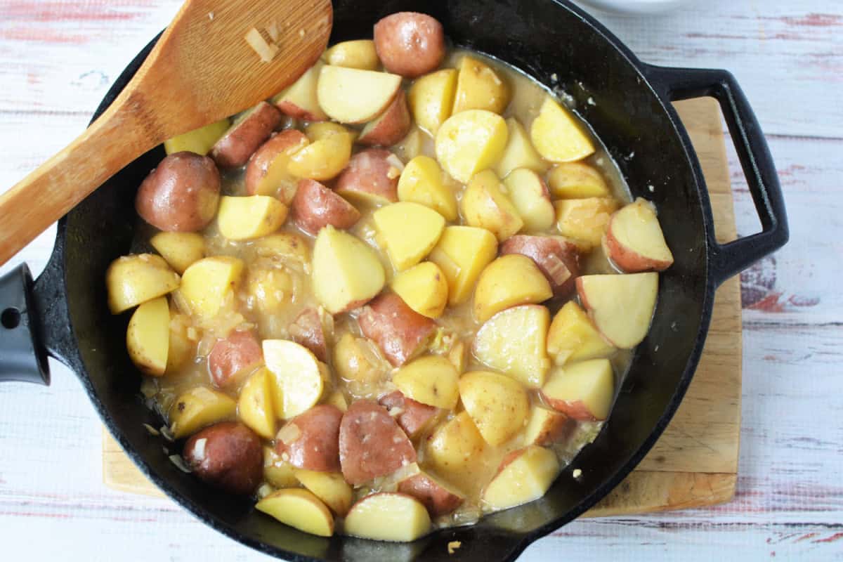 potatoes cooking in a cast iron skillet