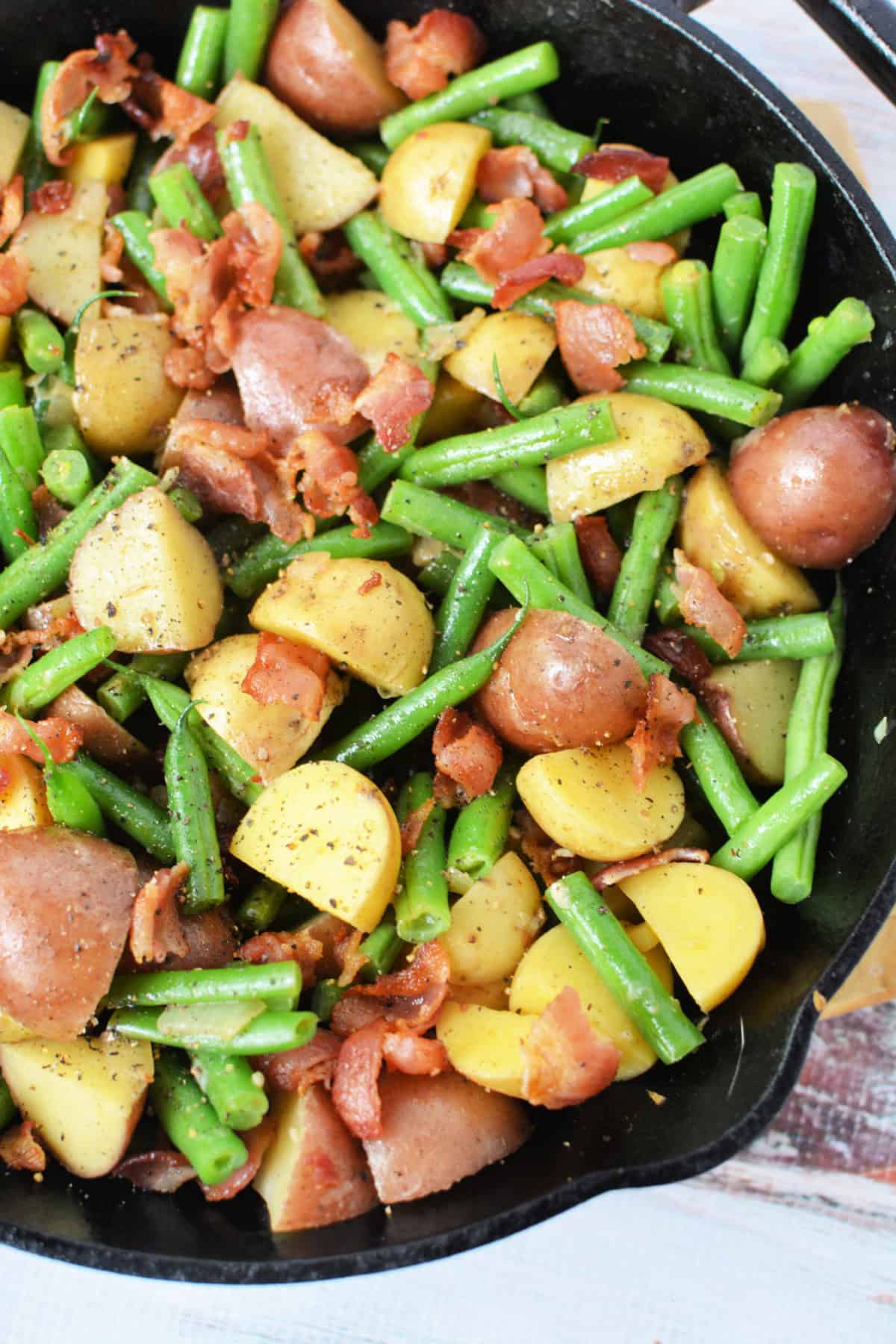 Potatoes and Green Beans with bacon in a cast iron skillet