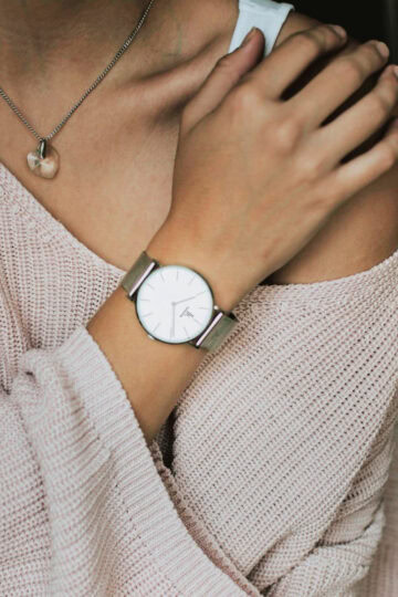silver watch against a pink sweater