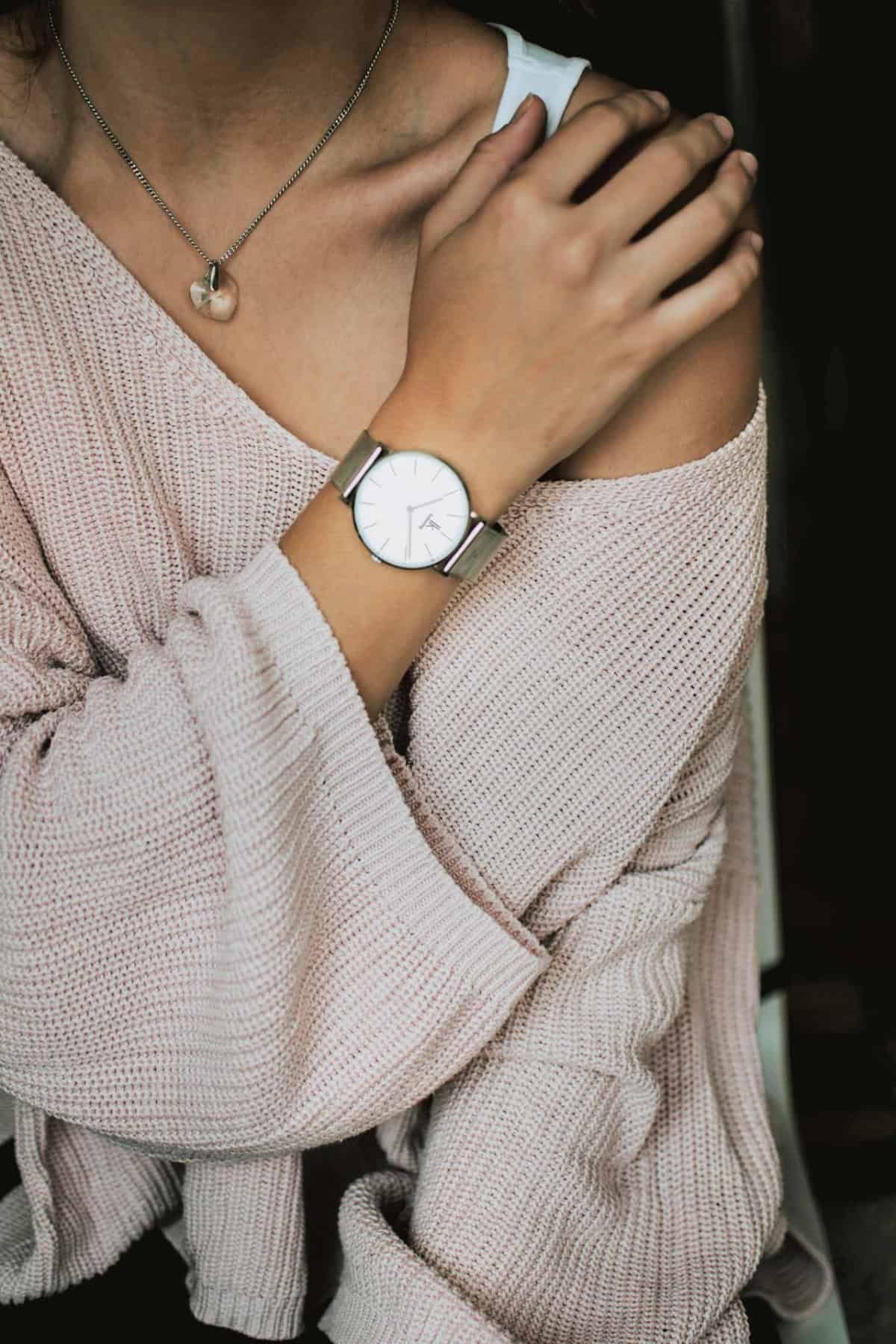 silver watch against a pink sweater