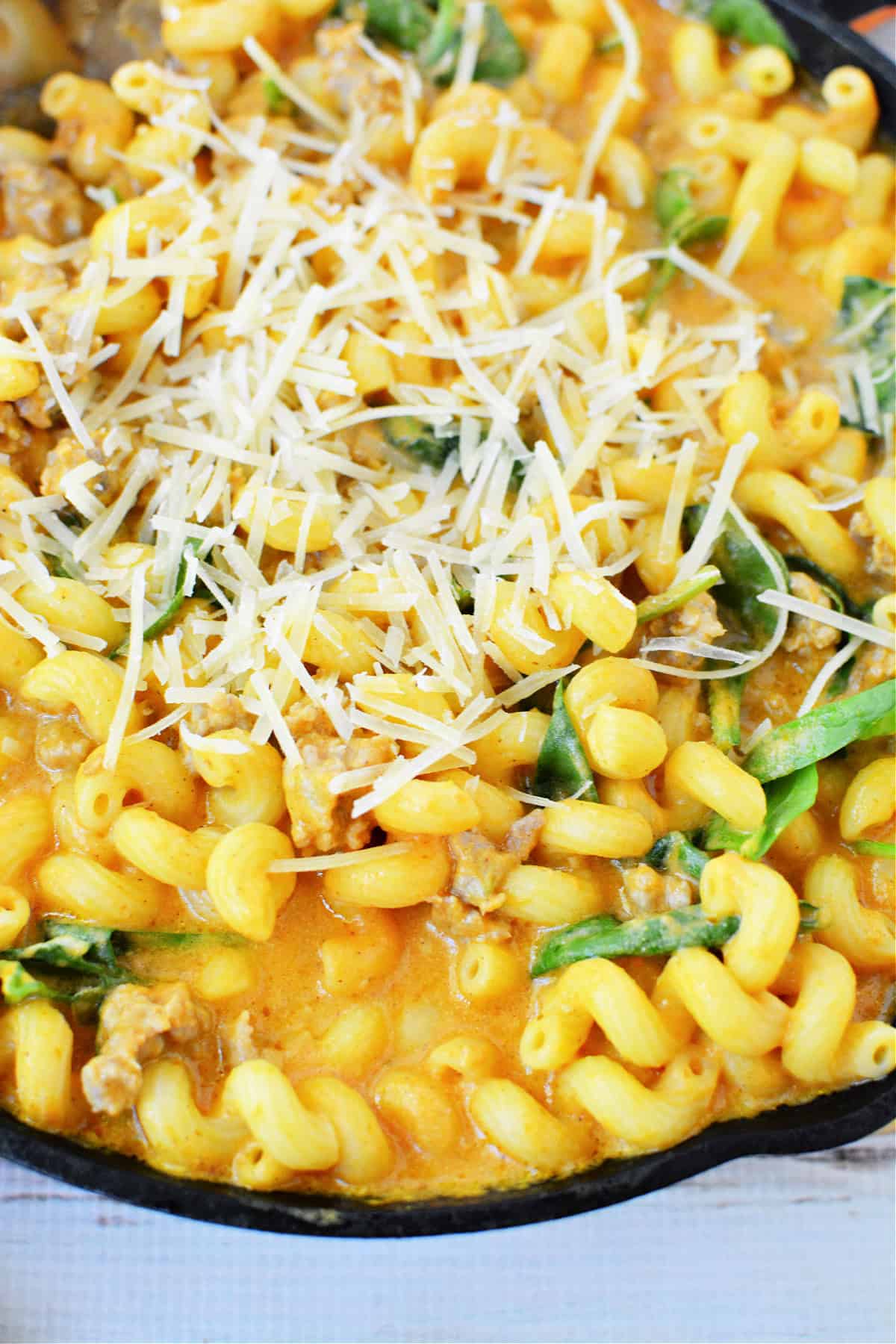Creamy Italian Sausage Pasta with Pumpkin and spinach topped with parmesan cheese