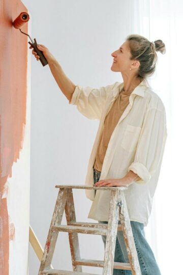 woman painting a wall in her home