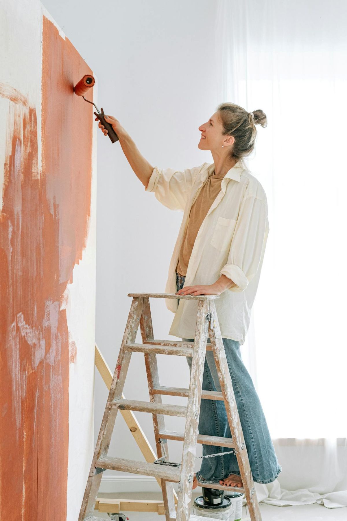 woman painting a wall in her home