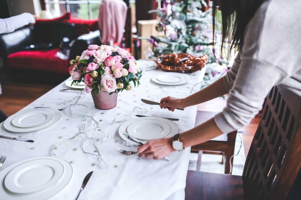 catered dinner party with table place setting and roses