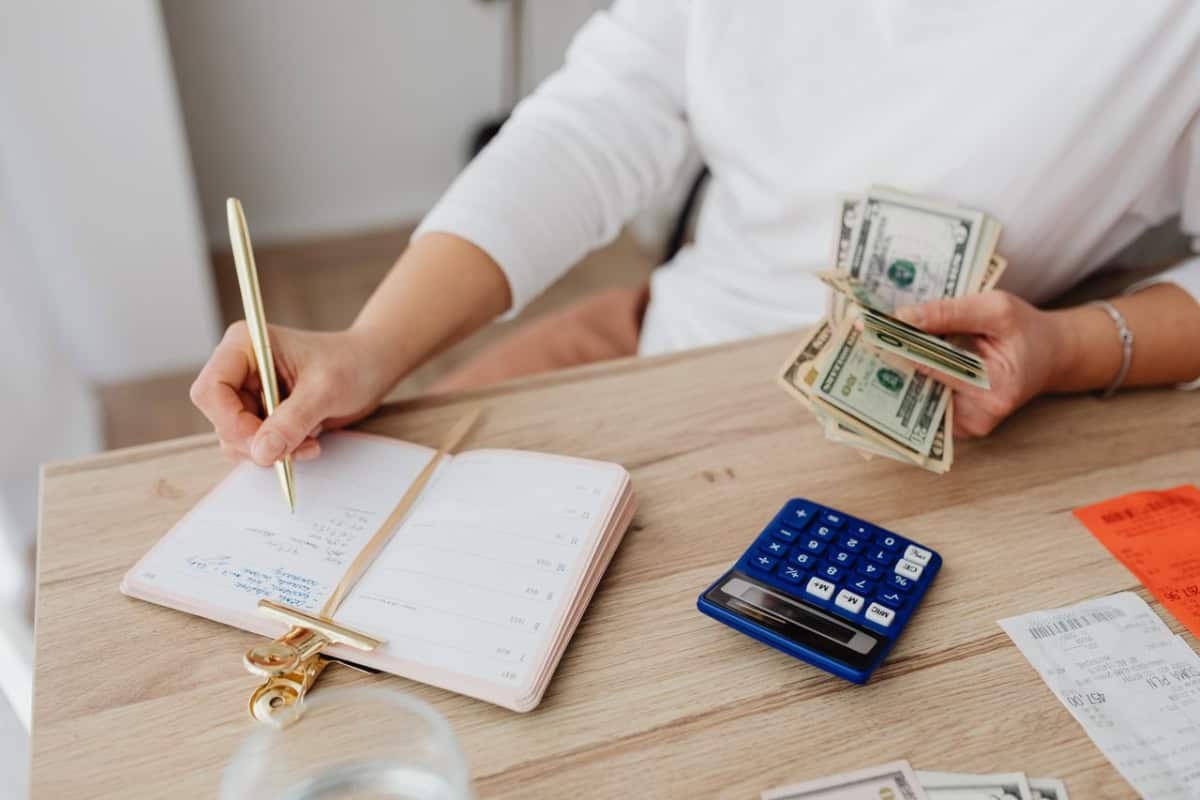 woman budgeting with calculator and cash in hand