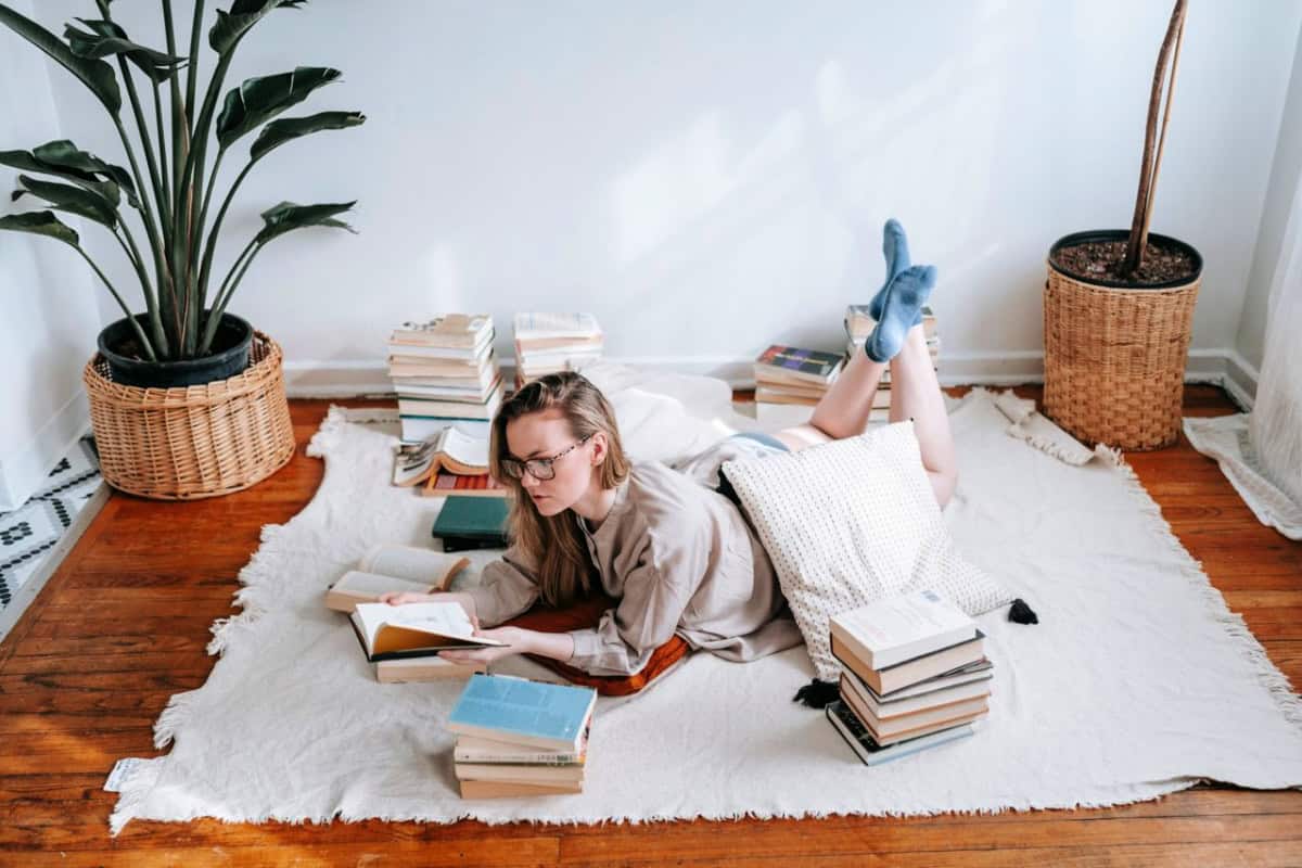 woman reading a book near a bookshelf