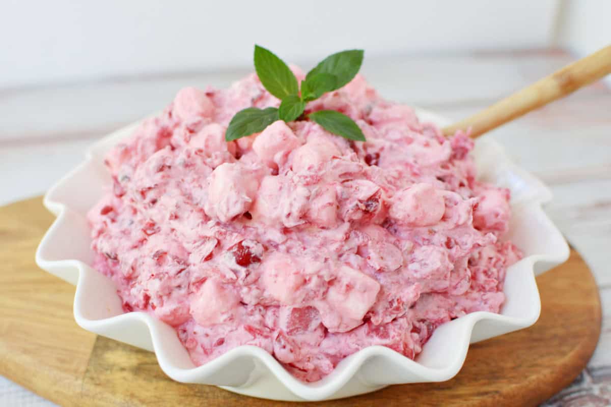 Cranberry Fluff in a white serving bowl with a wooden spoon